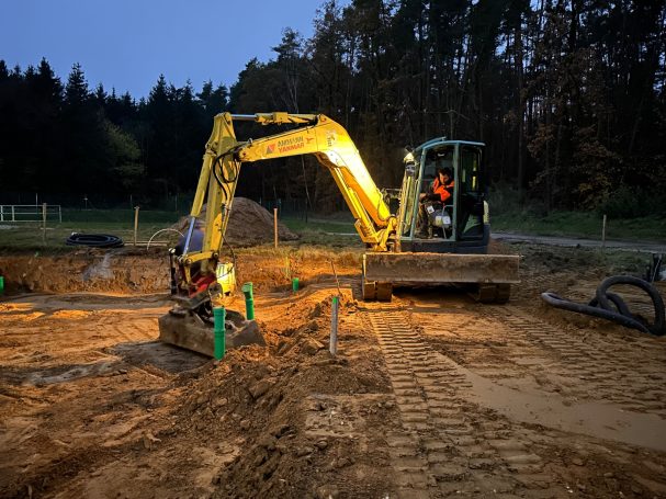 Erdarbeiten Ein Bagger auf einer Baustelle bei Abend